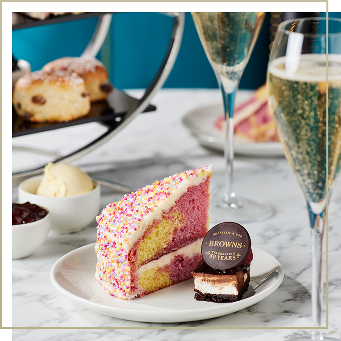 Birthday style cake on a plate served with champagne for afternoon tea at Browns Covent Garden