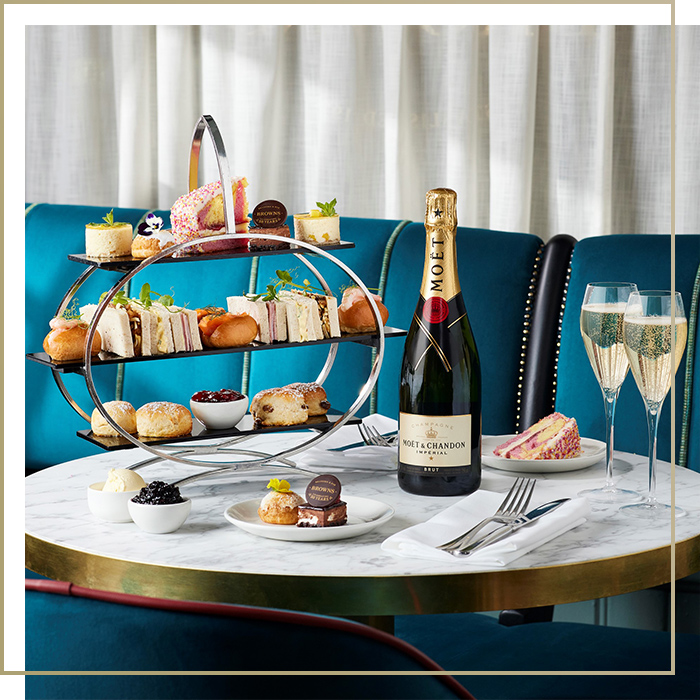 Birthday style cake on a plate served with champagne for afternoon tea at [outlet]